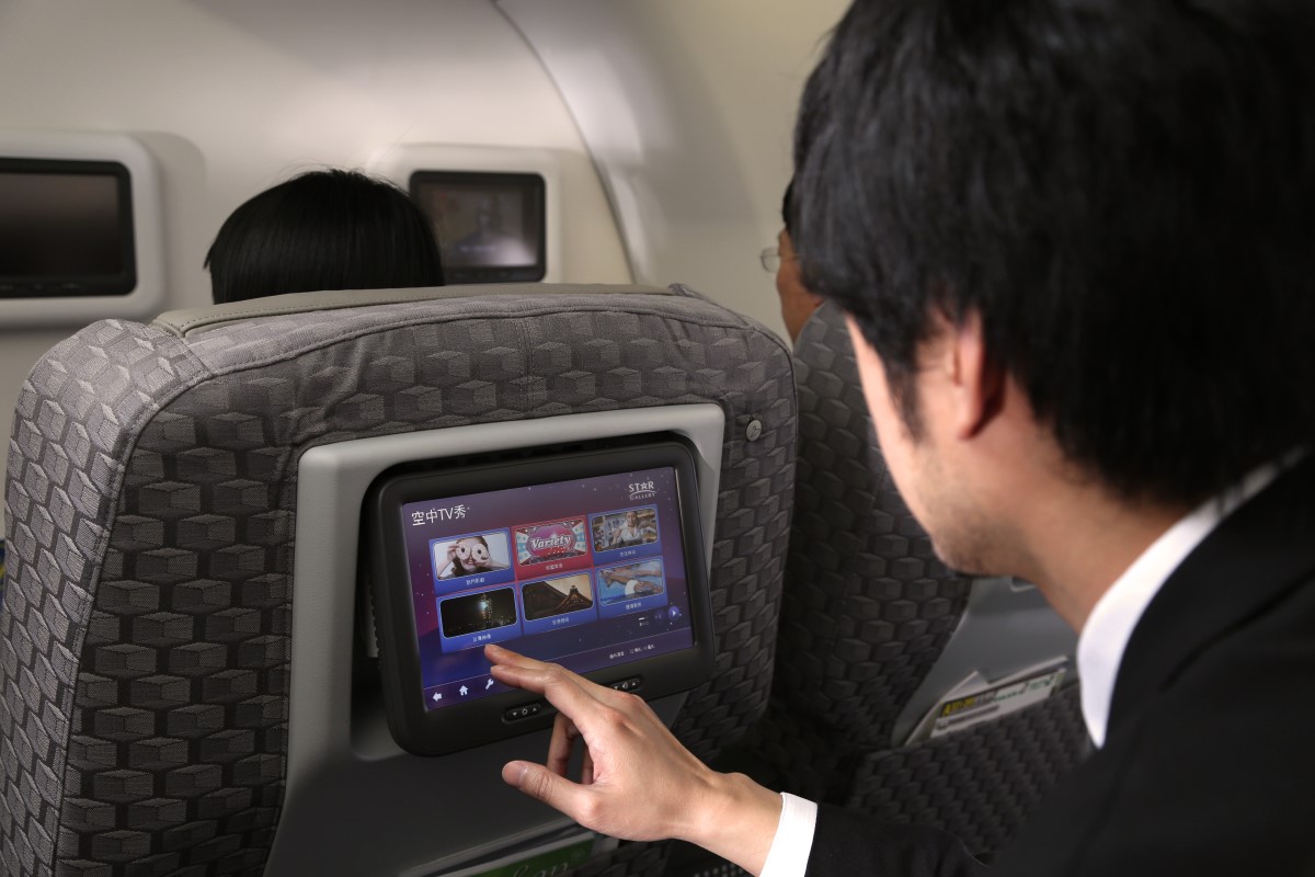乘客操作商务舱的个人触控屏幕